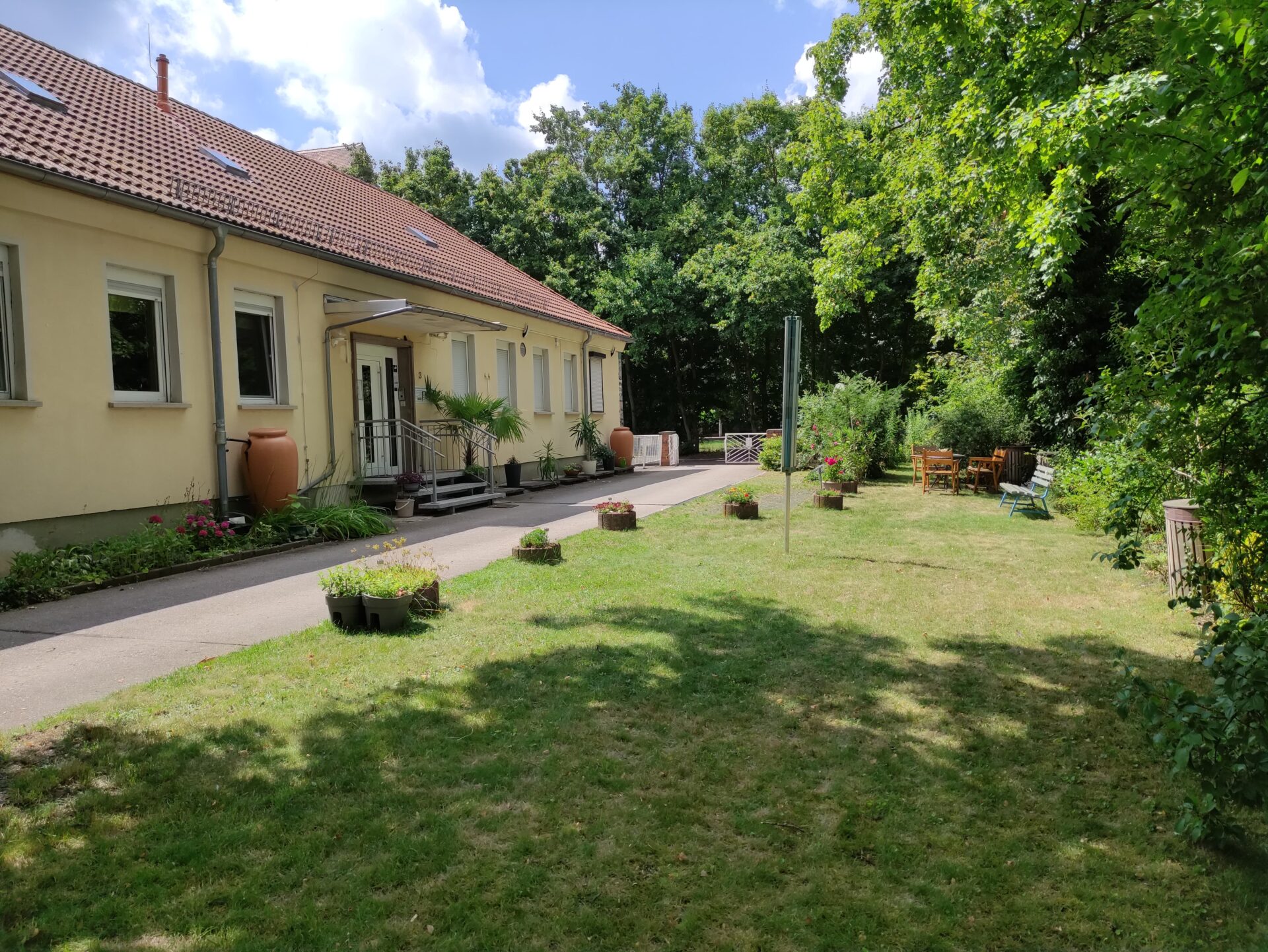 Umgeben von viel Grün, liebevoll gepflegtem Garten und gemütlichen Sitzmöglichkeiten genießen Mitarbeitende wie Patient:innen gleichermaßen eine ruhige Atmosphäre – ideale Voraussetzungen für konzentriertes Arbeiten und nachhaltige Erholung.
© Physiotherapie an der Lutherkirche